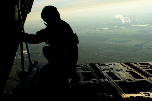 U.S. Air Force Senior Airman Patrick Cassidy, 37th Airlift Squadron loadmaster, peers out the back of a C-130J Super Hercules after air dropping more than 50 paratroopers over the skies of Germany, Nov. 30, 2016. The crew, stationed at Ramstein Air Base, assisted in International Jump Week by providing aircraft for the paratroopers to jump from. (U.S. Air Force photo by Senior Airman Jonathan Bass)