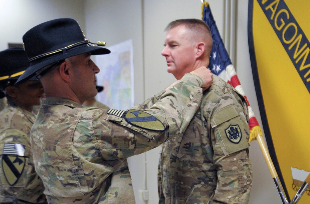 Army Col. Chris Colavita presents the Combat Action Badge to Col. Rick Ellis for his lifesaving actions on the battlefield. 