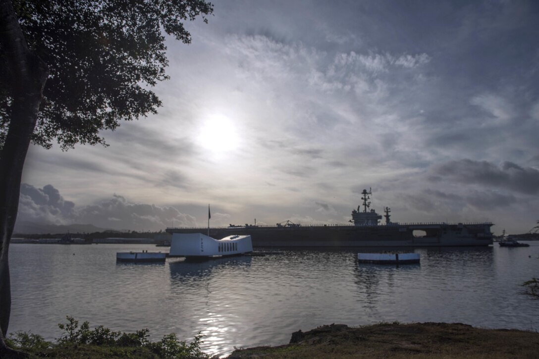 The aircraft carrier USS John C. Stennis passes the USS Arizona Memorial as the ship prepares to moor at Joint Naval Base Pearl Harbor-Hickam, Dec. 2, 2016. Navy photo by Petty Officer 2nd Class Aiyana S. Paschal