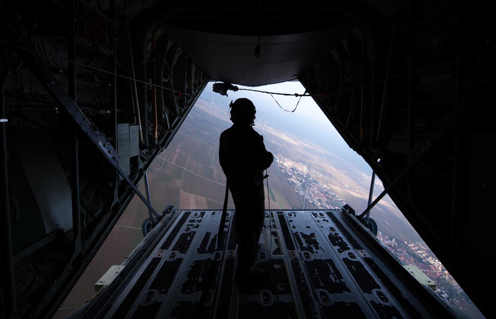 Senior Airman Patrick Cassidy, 37th Airlift Squadron loadmaster, observes as North Atlantic Treaty Organization paratroopers jump out of a C-130J Super Hercules during an International Jump Week exercise over Germany Dec. 1, 2016. Cassidy oversaw dozens of NATO Allied nation service members as they took part in training. (U.S. Air Force photo by Airman 1st Class Lane T. Plummer)