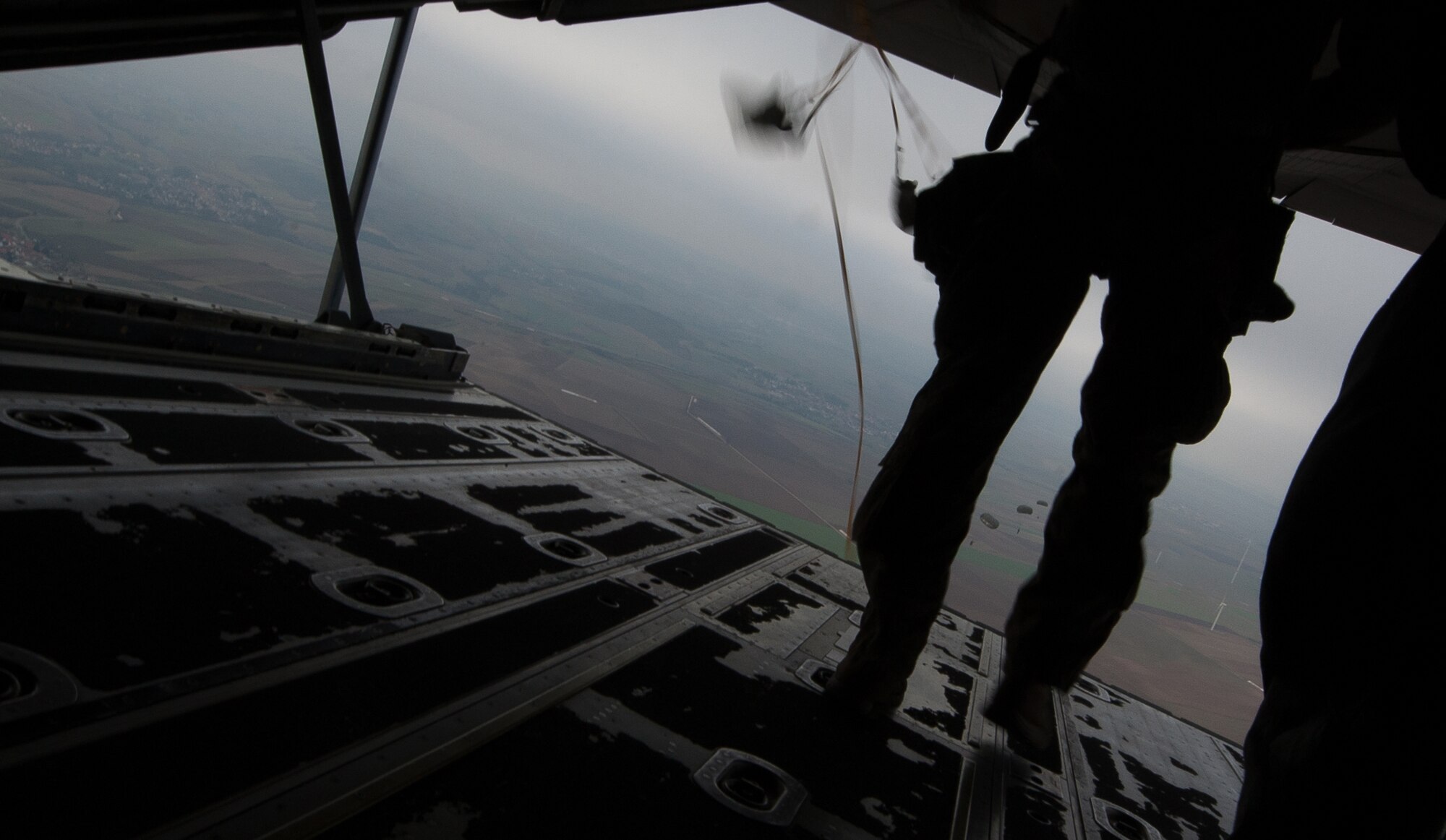 NATO allied nation paratroopers jump out the back of a C-130J Super Hercules during an International Jump Week exercise over Germany Dec. 1, 2016. As part of the exercise, Ramstein Air Base assisted by providing aircraft for the paratroopers to jump from. (U.S. Air Force photo by Airman 1st Class Lane T. Plummer)
