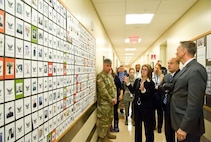 Todd Weiler, Assistant Secretary of Defense for Manpower and Reserve Affairs, and Ronald Keohane, Deputy Assistant Secretary of Defense for Military Community and Family Policy; listen to Deborah Skillman, Director, Casualty, Mortuary Affairs and Military Funeral Honors from the Office of the Deputy Assistant Secretary of Defense for Military Community and Family Policy, explain the display board of confirmed USS Oklahoma (BB 37) remains identified by the Armed Forces DNA Identification Laboratory Nov. 4, 2016, at Armed Forces Medical Examiner System on Dover Air Force Base, Del. Weiler and Keohane received briefings and met with personnel at the Air Force Mortuary Affairs Operations, AFMES and the Joint Personal Effects Depot. (U.S. Air Force photo by Roland Balik)