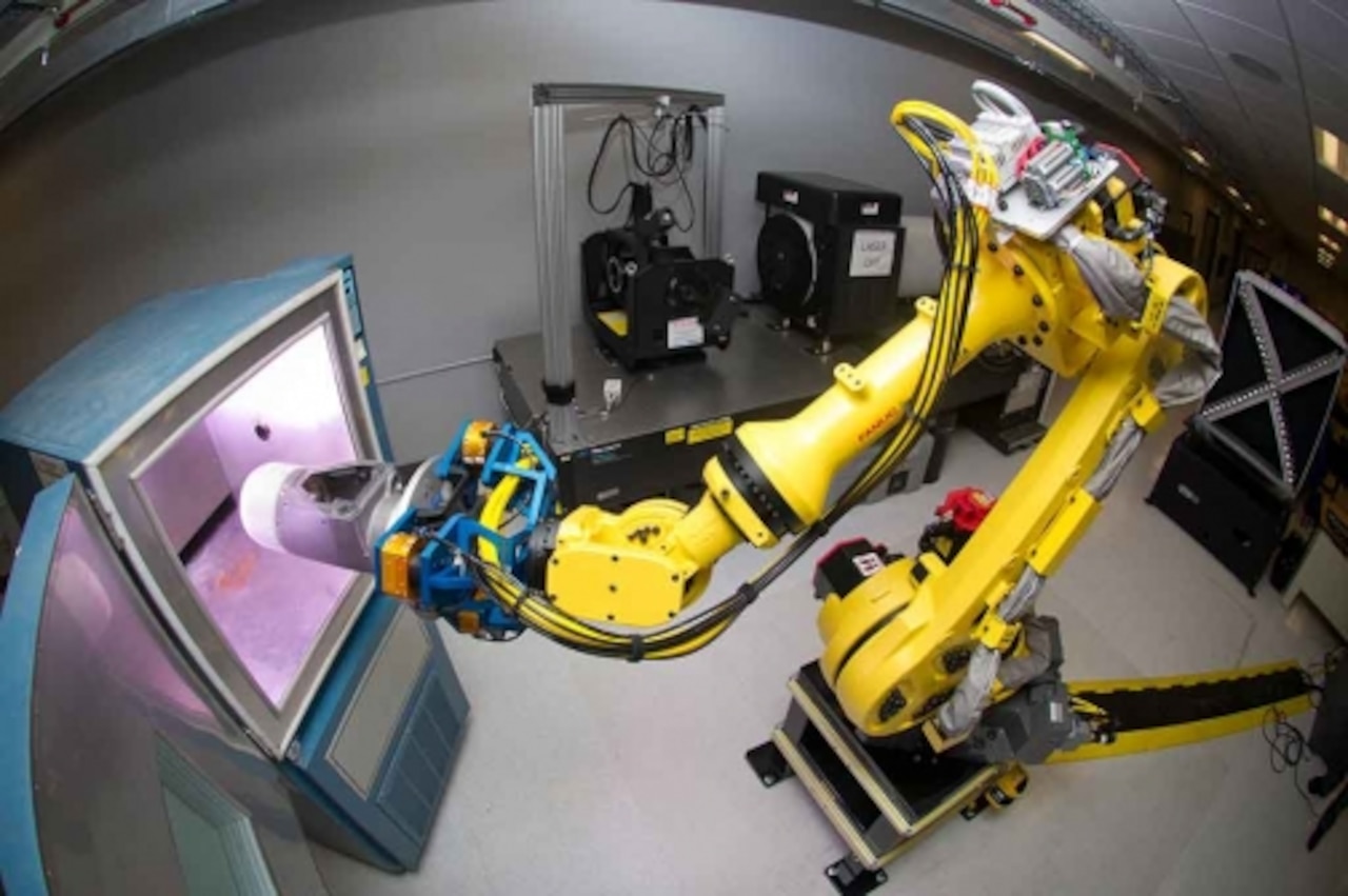 A robotic arm places a small-diameter bomb II guidance section into a test cell. Courtesy photo