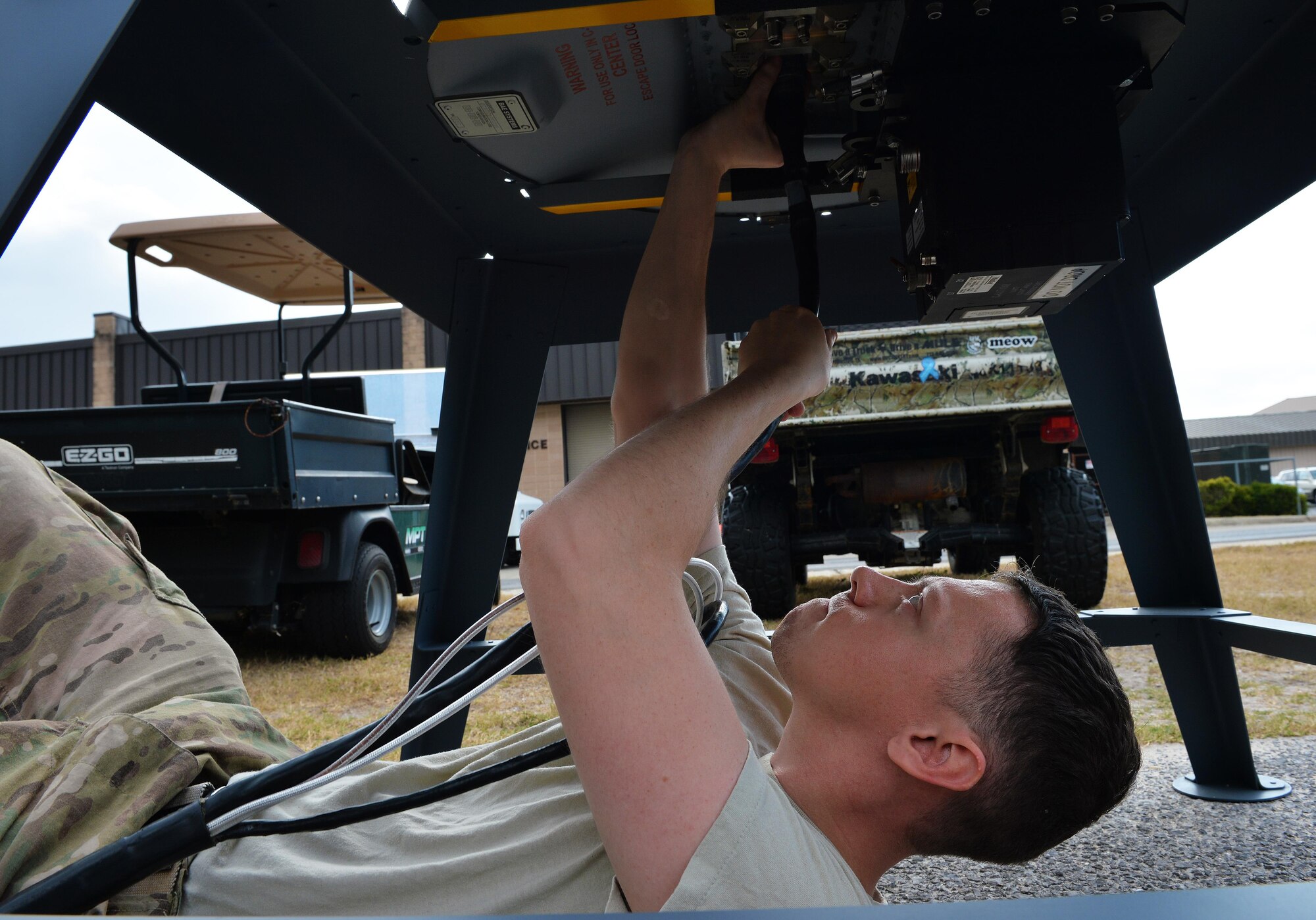 Staff Sgt. Ryan Hart, a radio frequency transmission system supervisor with the 1st Special Operations Communications Squadron, hooks a radio frequency system cable to a Ku Spread Spectrum antenna at Hurlburt Field, Fla., Nov. 29, 2016. This cable sends signals and controls data to the KuSS antenna from the internal reference unit. The internal reference unit distributes power to an assembly of modems and routers that control the antenna and log collected data. (U.S. Air Force photo by Senior Airman Andrea Posey)