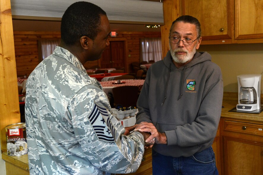 U.S. Air Force Chief Master Sgt. Christopher McKinney, 20th Fighter Wing command chief, receives a coin from Curt Marshall, 20th Force Support Squadron Wateree Recreation Area manager, as thanks for taking the time to recognize Wateree Recreation Area staff for their hard work near Camden, S.C., Nov. 28, 2016. With the completion of two new cabins, Wateree staff are now responsible for the care and upkeep of 16 cabins, 22 recreational vehicle sites and 25 wooded acres. (U.S. Air Force photo by Airman 1st Class Kelsey Tucker)