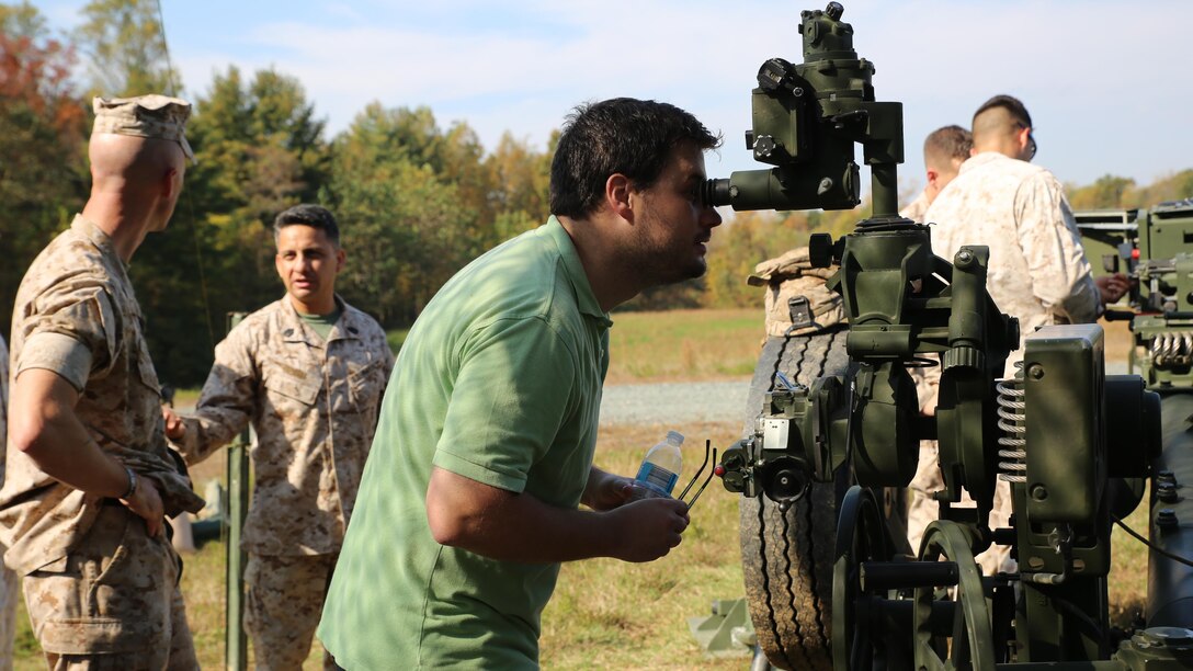 Caleb Hughes, the large-caliber ammunition engineer at MCSC’s Ammunition Program Management Office, looks through a sight used to align the M777 howitzer to a target during a field artillery demonstration at Marine Corps Training Command aboard Marine Corps Base Quantico last month. During the demonstration MCSC employees gained first-hand experience of field artillery Marines in action to inform their work behind the scenes at MCSC. 