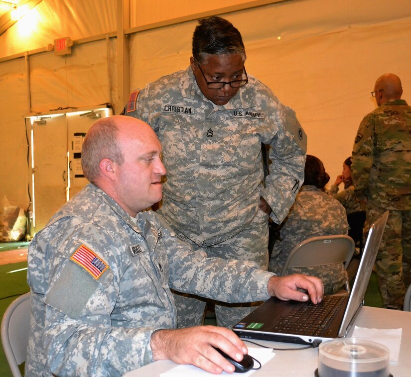 Staff Sgt. Anthony Griswold, 650th Regional Support Group personnel noncommission officer, and Sgt. 1st Class Cecile Christian, 650th personnel NCOIC, work at the Reception Staging Onward-Movement Integration station at the Fort Irwin National Training Center November 17-20, where the 650th RSG and 304th Sustainment Brigade conducted a joint FTX, during a MUTA 8 four-day battle assembly, where collective training events as well as individual readiness focused on medical readiness and firearms qualification.