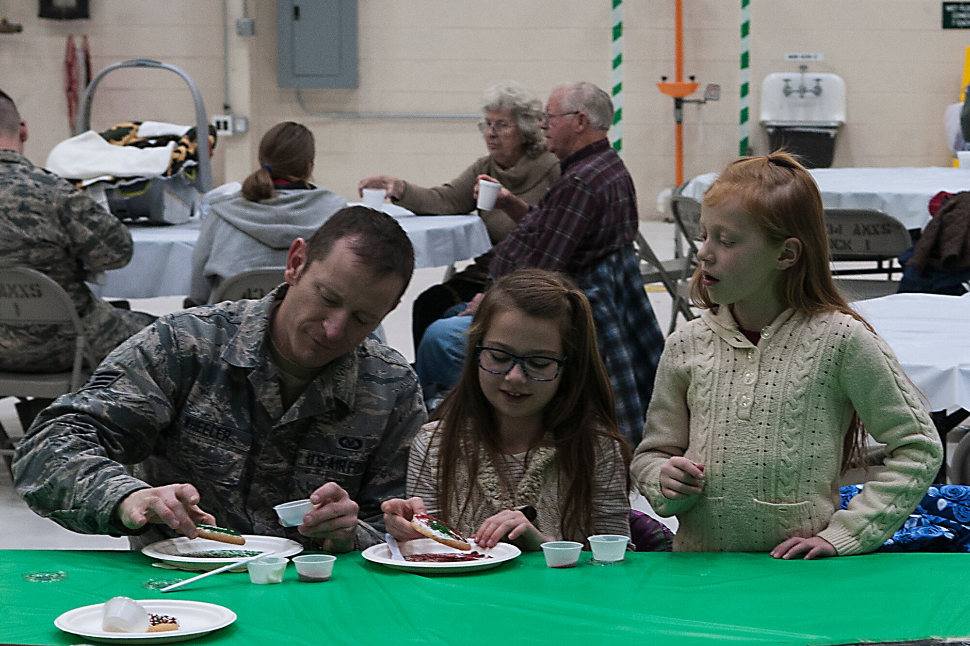 Senior Airman William Wheeler, 434th Operation Support Squadron aircrew flight equipment technician, decorates cookies with his family during a family appreciation Christmas party at Grissom Air Reserve Base, Ind. Dec. 2, 2016. The event featured Santa and his workshop for families to get photos, a table full of toys for children, hot cocoa and stations to decorate cookies and Christmas tree ornaments. (U.S. Air Force photo/Staff Sgt. Dakota Bergl) 