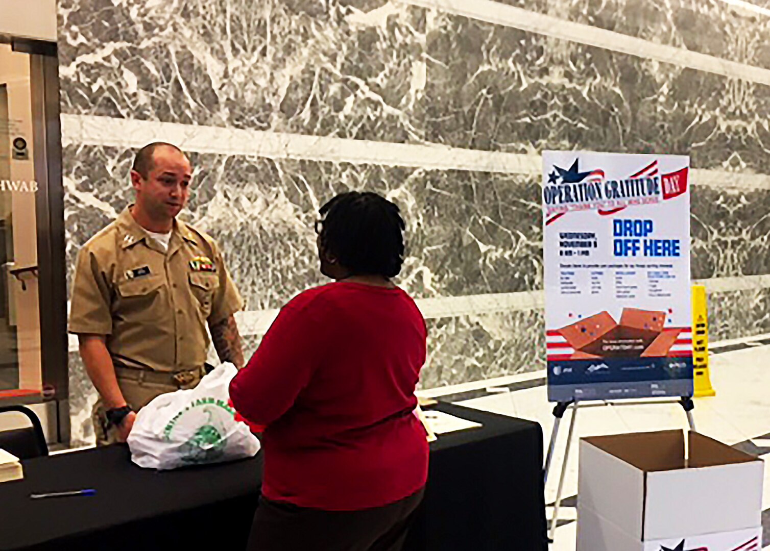 Navy Lt. Anthony Meyer speaks with an employee working at One Liberty Place in downtown Philadelphia Nov. 8. Meyer, a contract specialist with Subsistence, gave her a handful of cards for her co-workers to sign and include in care packages for warfighters as part of Operation Gratitude.