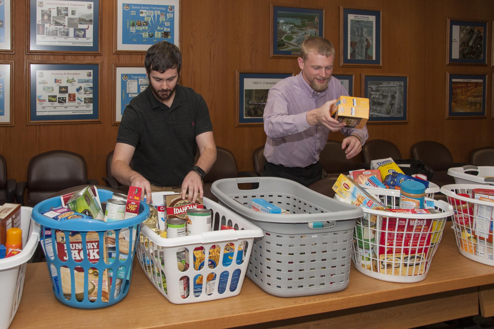 Arnold Junior Force Council members Adam Moon, left, and Brandon Hoffman, president, prepare food items at AEDC Nov. 16 for the Thanksgiving Food Basket Program, which is part of the Coffee County Backpack Program. The JFC delivered 19 food baskets with help from AEDC team members and their food dona¬tions. (U.S. Air Force photo/Jacqueline Cowan)