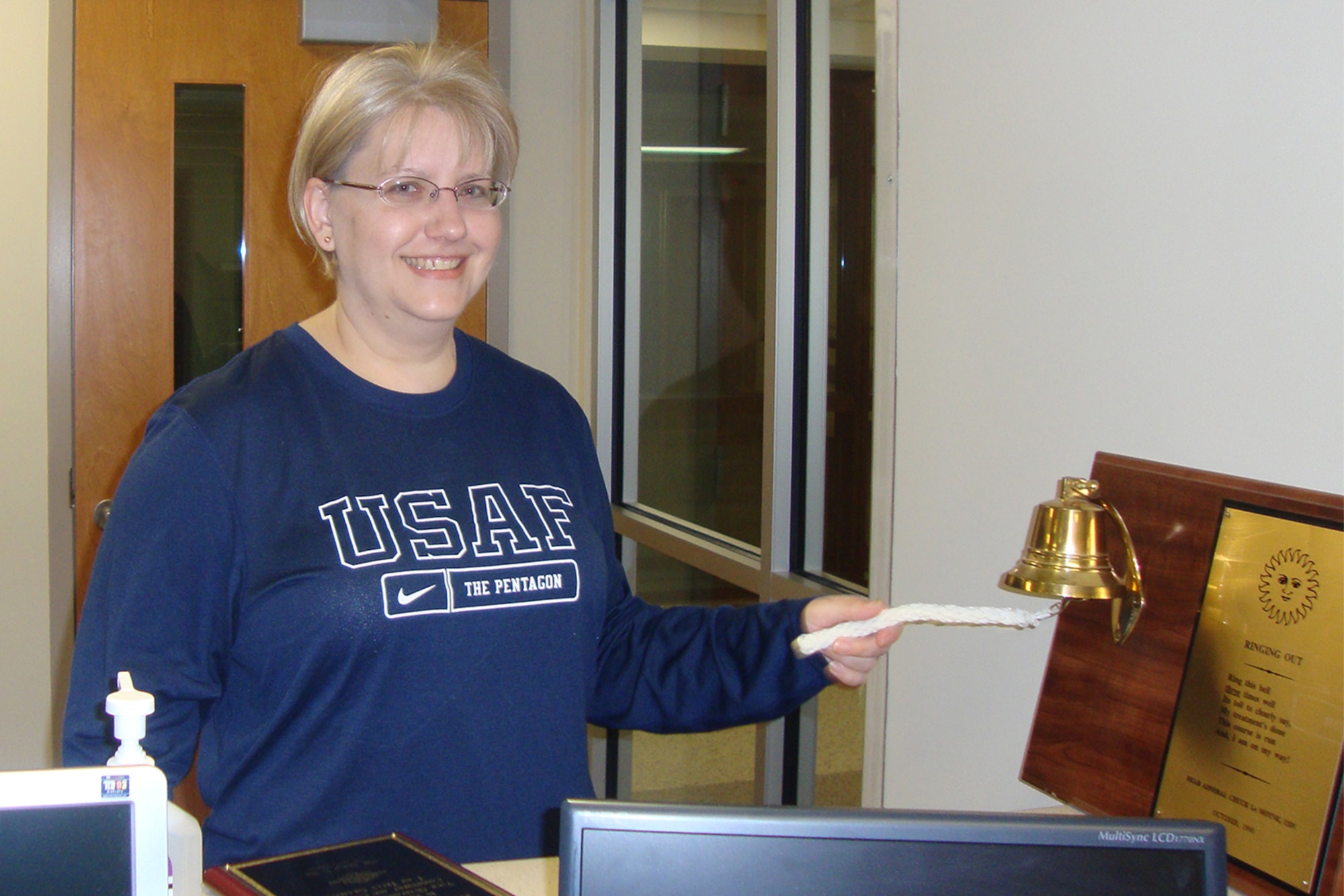 PETERSON AIR FORCE BASE, Colo. – Lt. Col. Christine Millard, 21st Comptroller Squadron commander, rings a bell on the last day of radiation treatment at Bethesda Medical Center in 2011. It's a tradition for cancer patients to ring the bell at the end of chemotherapy and again at the end of radiation treatment. (Courtesy photo by Lt. Col. Christine Millard)