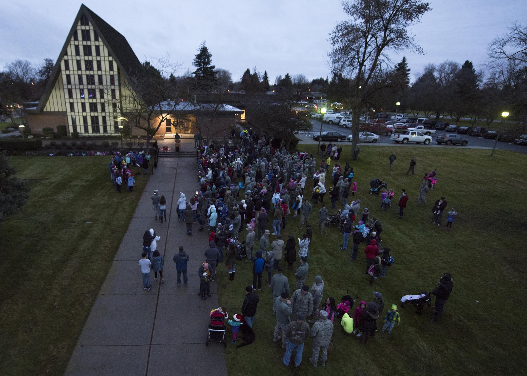 Fairchild Airmen and their families gather in front of the base chapel for the annual Fairchild Holiday Tree Lighting Ceremony Dec. 2, 2016, Fairchild Air Force Base, Wash. Col. Ryan Samuelson, the 92nd Air Refueling Wing commander, hosted the ceremony, joined the crowd and led the children in lighting the tree. (U.S. Air Force photo/Airman 1st Class Ryan Lackey)