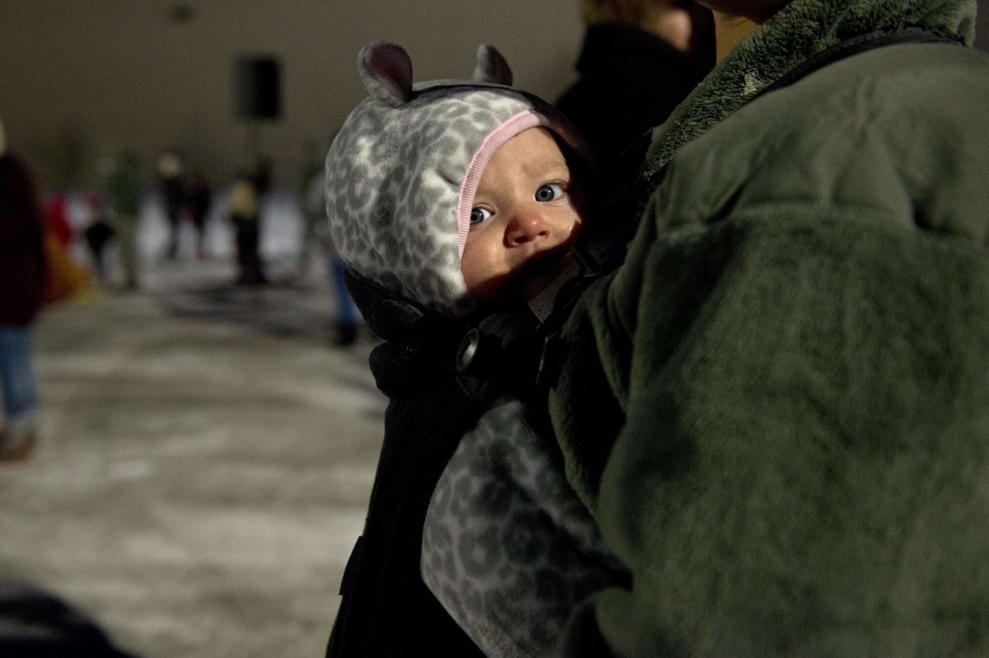 Service members and families watch the Ursa Major Elementary School choir sing Christmas songs during the annual Joint Base Elmendorf-Richardson Holiday Tree Lighting, at JBER, Alaska, Dec. 1, 2016. The annual event brings service members, families, and wing leadership together to begin the holiday season.