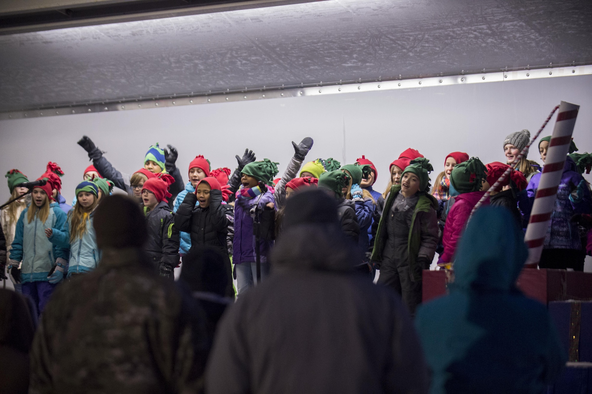 Service members and families watch the Ursa Major Elementary School choir sing Christmas songs during the annual Joint Base Elmendorf-Richardson Holiday Tree Lighting, at JBER, Alaska, Dec. 1, 2016. The annual event brings service members, families, and wing leadership to begin the holiday season. 