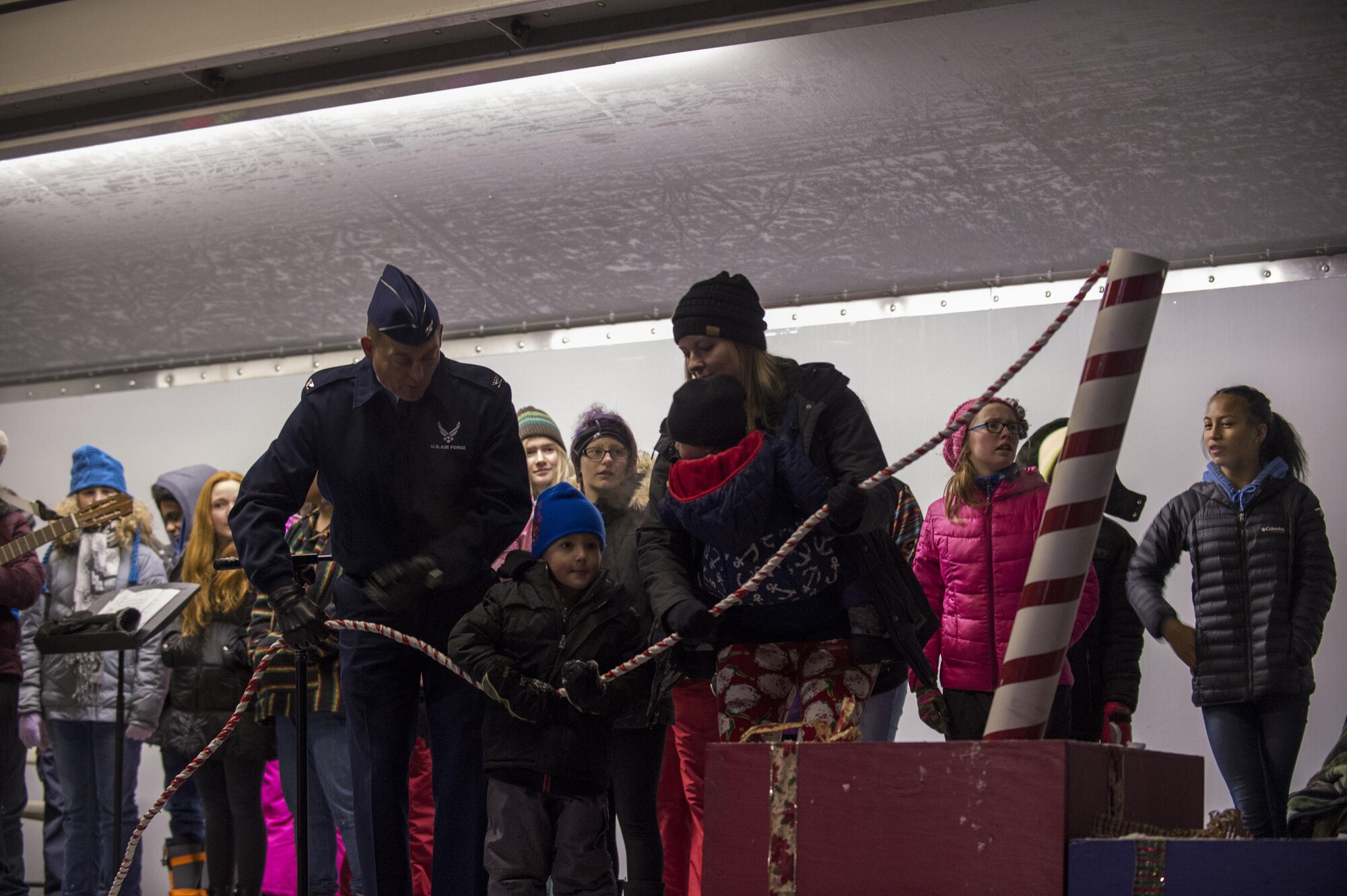Air Force Col. George Dietrich, Joint Base Elmendorf-Richardson and 673d Air Base Wing commander, and a deployed member's family pull the switch for the Holiday tree lighting in front of the Joint Military Mall, Dec. 1, 2016. 