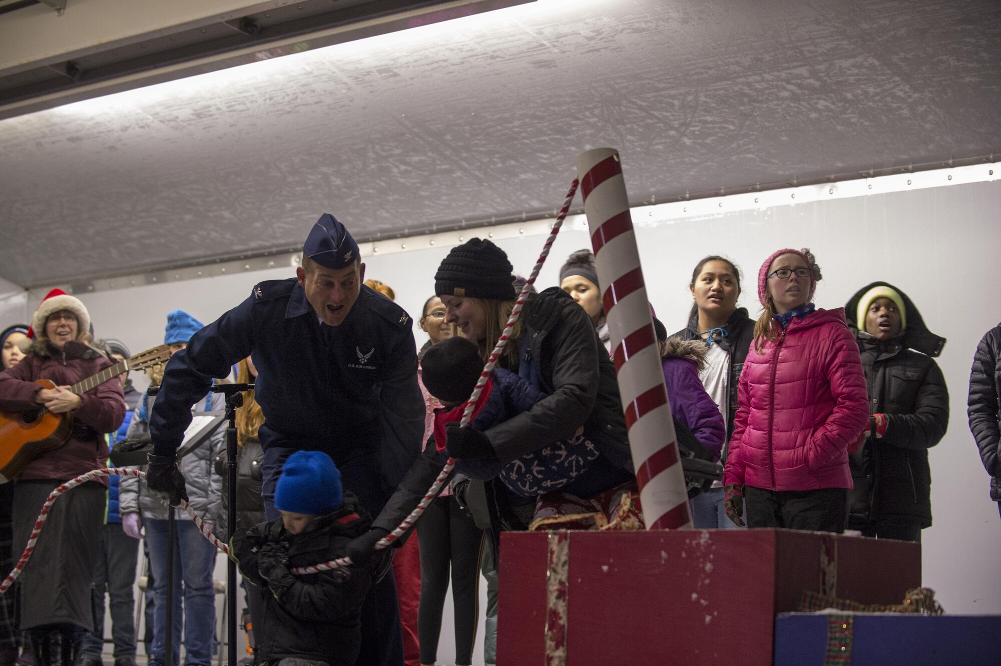 Air Force Col. George Dietrich, Joint Base Elmendorf-Richardson and 673d Air Base Wing commander, and a deployed member's family pull the switch for the Holiday tree lighting in front of the Joint Military Mall, Dec. 1, 2016. 