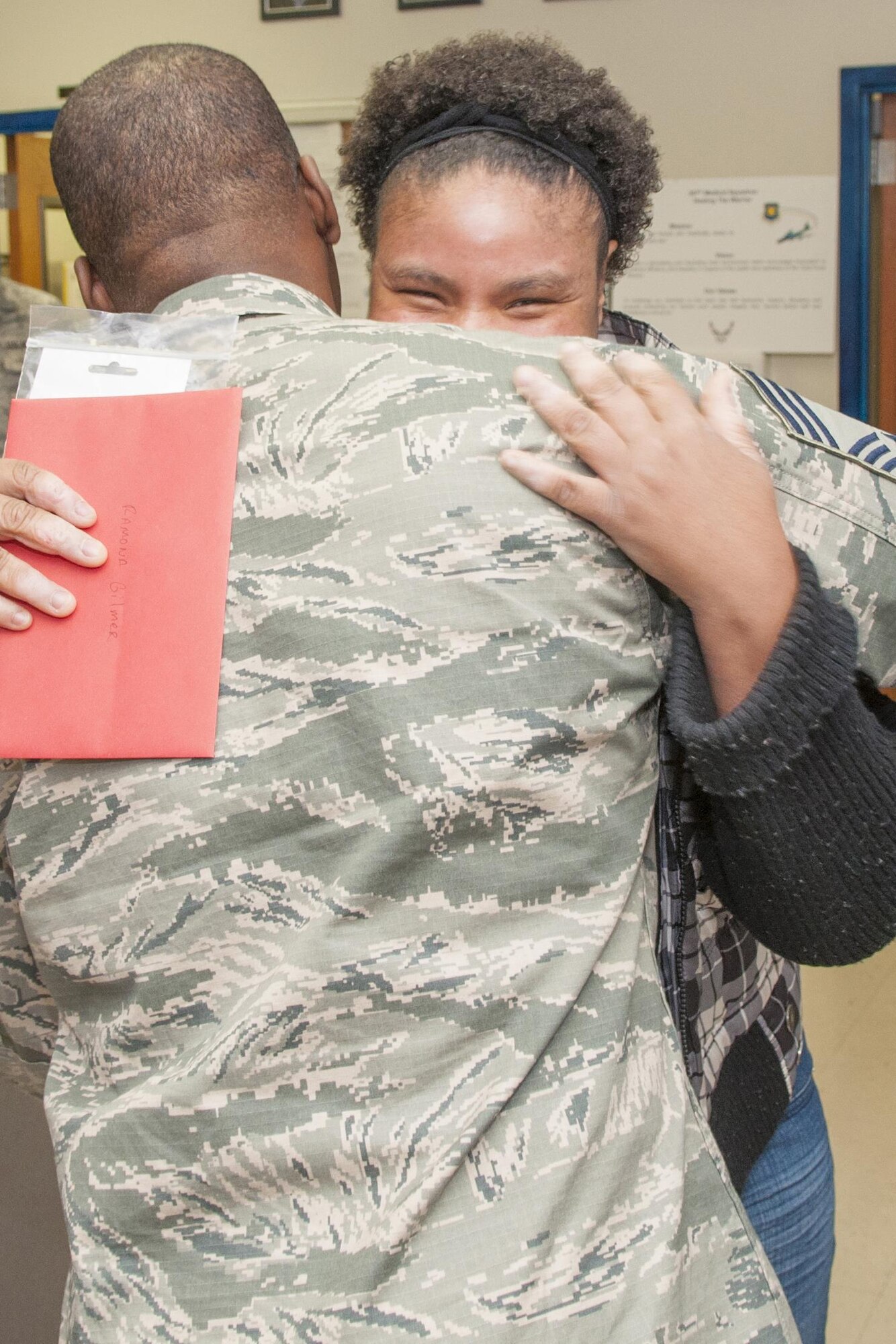 U.S. Air Force Senior Airman Ramona Gilmer, 307th Medical Squadron health services attendant, gives a hug to Chief Master Sgt. Jimmy Mobley, 307th Civil Engineering Squadron fire protection superintendent, at Barksdale Air Force Base, La., Dec. 4, 2016.   Mobley and several other firefighters presented Gilmer with a gift certificate and morale t-shirt as part of an annual program to recognize Airmen going above and beyond to help others.   She recently went to great lengths to help family members going through severe crisis. (U.S. Air Force photo by Tech. Sgt. Cody Burt/released)