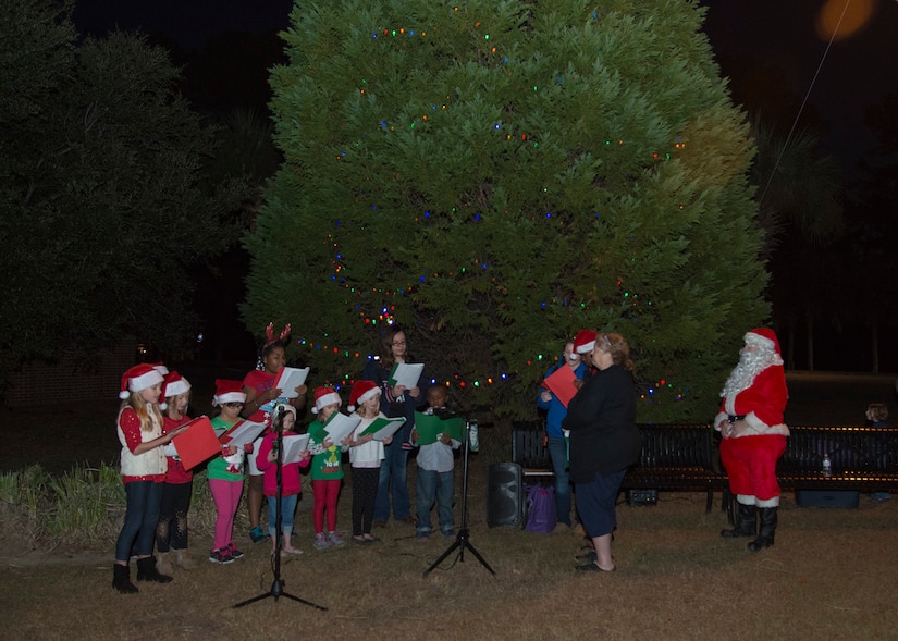 Santa Claus joins Christmas carolers as they sing during the annual Joint Base Charleston - Weapons Station holiday tree lighting ceremony Dec. 1, 2016. Families and children gathered for caroling, hot chocolate, photos with Santa and the annual lighting of the holiday tree on base. 