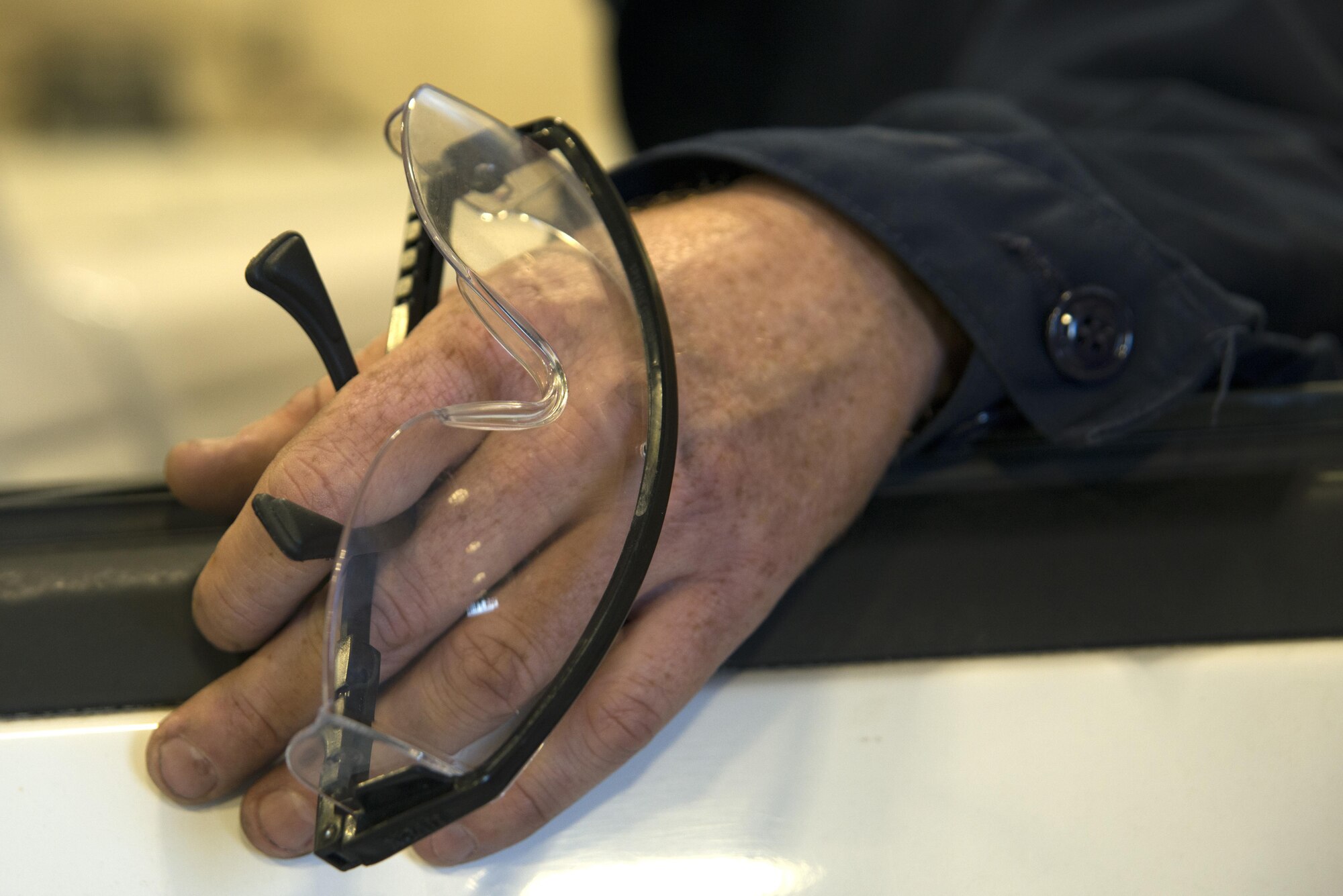 U.S. Air Force Staff Sgt. Joshua Patterson, 20th Logistics Readiness Squadron vehicle maintenance journeyman, holds safety glasses after visually inspecting the undercarriage of a government-owned vehicle at Shaw Air Force Base, S.C., Dec. 1, 2016. Vehicle maintenance Airmen wear a variety of personal protective equipment such as safety glasses, gloves or hearing protection, depending on the type of maintenance being performed. (U.S. Air Force photo by Airman 1st Class Kathryn R.C. Reaves)