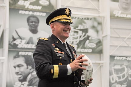 Maj. Gen. Troy D. Kok, commanding general of the U.S. Army Reserve’s 99th Regional Support Command headquartered at Joint Base McGuire-Dix-Lakehurst, New Jersey, gets ready to throw a football to New York Jets rookie linebacker Jordan Jenkins during a Dec. 4 event sponsored by the Jets. Kok was a guest speaker at the event, which honored roughly 100 Vietnam Veterans.