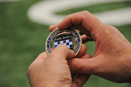 Maj. Gen. Troy D. Kok, commanding general of the U.S. Army Reserve’s 99th Regional Support Command headquartered at Joint Base McGuire-Dix-Lakehurst, New Jersey, shows off the new commander’s coin to New York Jets rookie linebacker Jordan Jenkins. Kok spoke at the team’s Vietnam Veterans event Dec. 4.