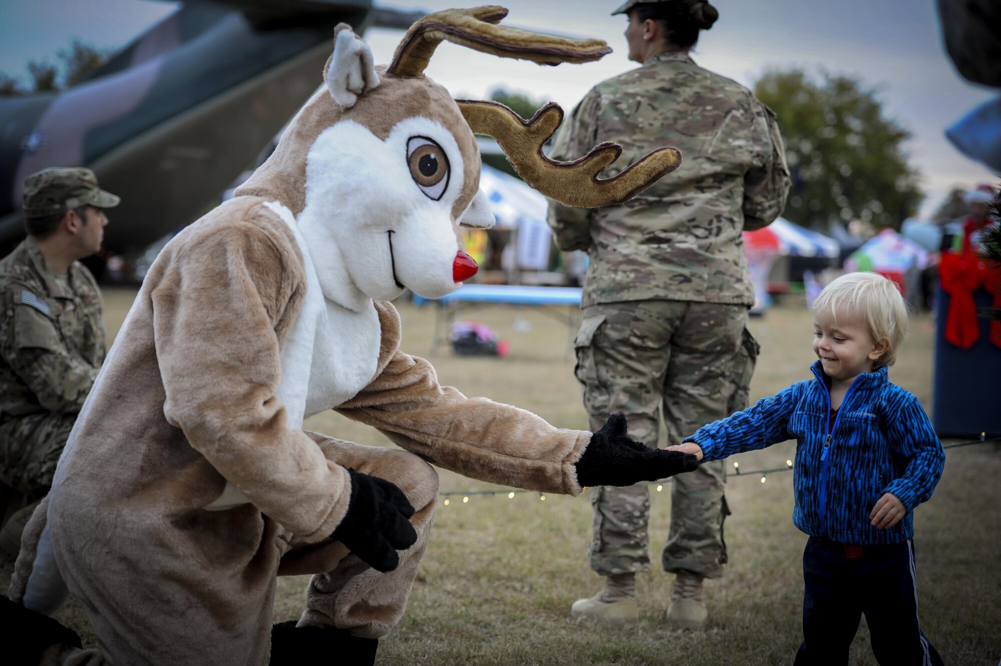 Rudolph gives a child a high-five during the Christmas tree lighting ceremony at Hurlburt Field, Fla., Dec. 2, 2016. Hurlburt Field held a Christmas tree lighting ceremony to celebrate the holiday season as an Air Force family. (U.S. Air Force photo by Airman Dennis Spain) 