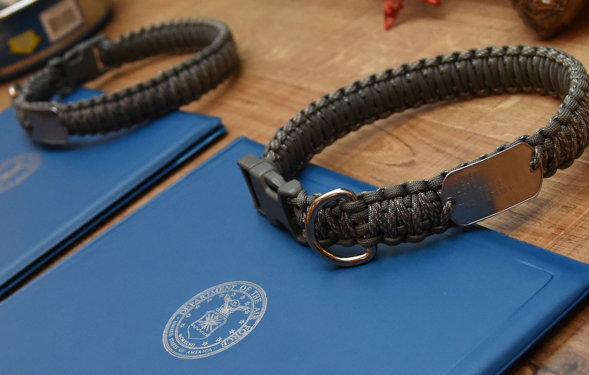 Retirement certificates and dog collars sit on display during a retirement ceremony for Densy and Ares, 81st Security Forces Squadron military working dogs, at the Keesler Medical Center Don Wylie Auditorium Dec. 2, 2016, on Keesler Air Force Base, Miss. Densy and Ares served more than 17 years combined in the Air Force. (U.S. Air Force photo by Kemberly Groue)