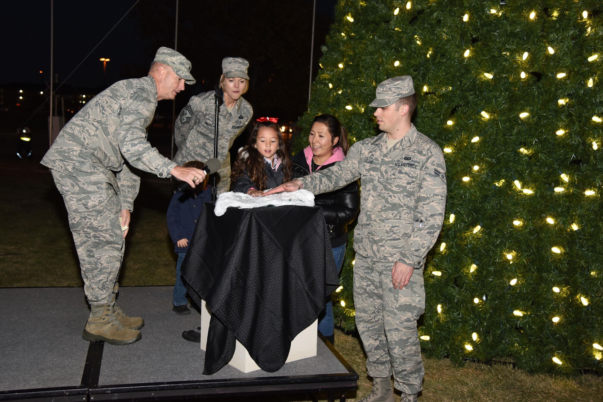 U.S. Air Force Col. Michael Downs, 17th Training Wing Commander, Chief Master Sgt. Bobbie Riensche, 17th TRW command chief, Airman 1st Class Jake Lucero, 17th Contracting Squadron contract administrator, and the Whitman family light up the Christmas tree at the parade field on Goodfellow Air Force Base, Texas, Dec. 1, 2016. Lucero lit the tree because he helped secure the contract to get it and the Whitman family participated because one of their family members is currently deployed. (U.S. Air Force photo by Staff Sgt. Joshua Edwards/Released)