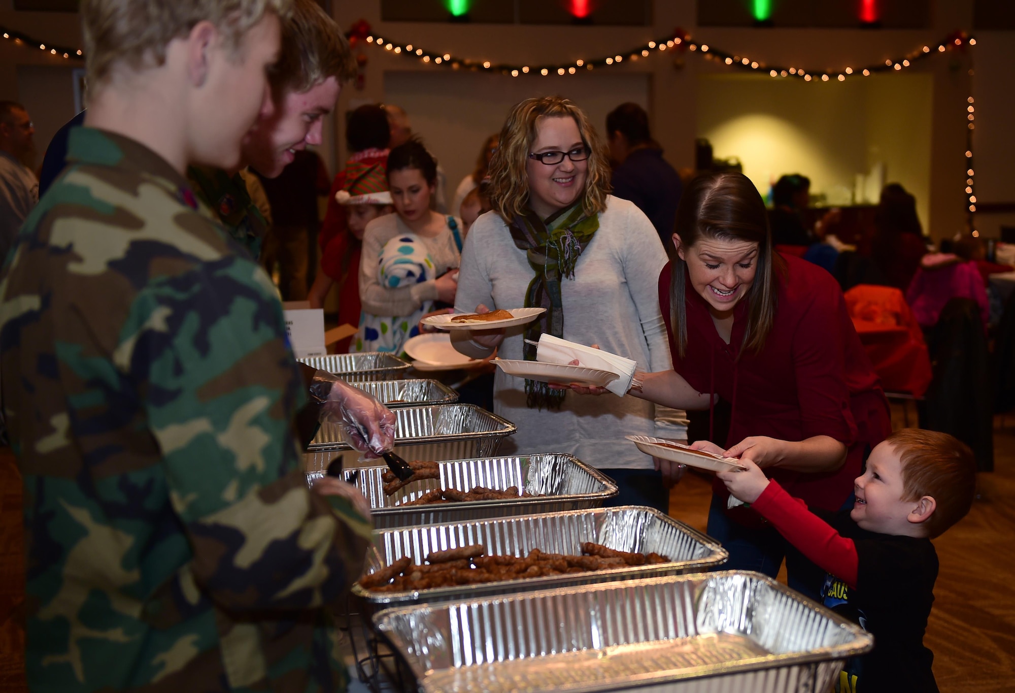 Wyatt, a Buckley child, receives sausage and pancakes at a Breakfast with Santa event Dec. 3, 2016, on Buckley Air Force Base, Colo. The event included free breakfast, pictures with Santa Claus, and a free present for every child. (U.S. Air Force photo by Airman Jacob Deatherage/Released) 