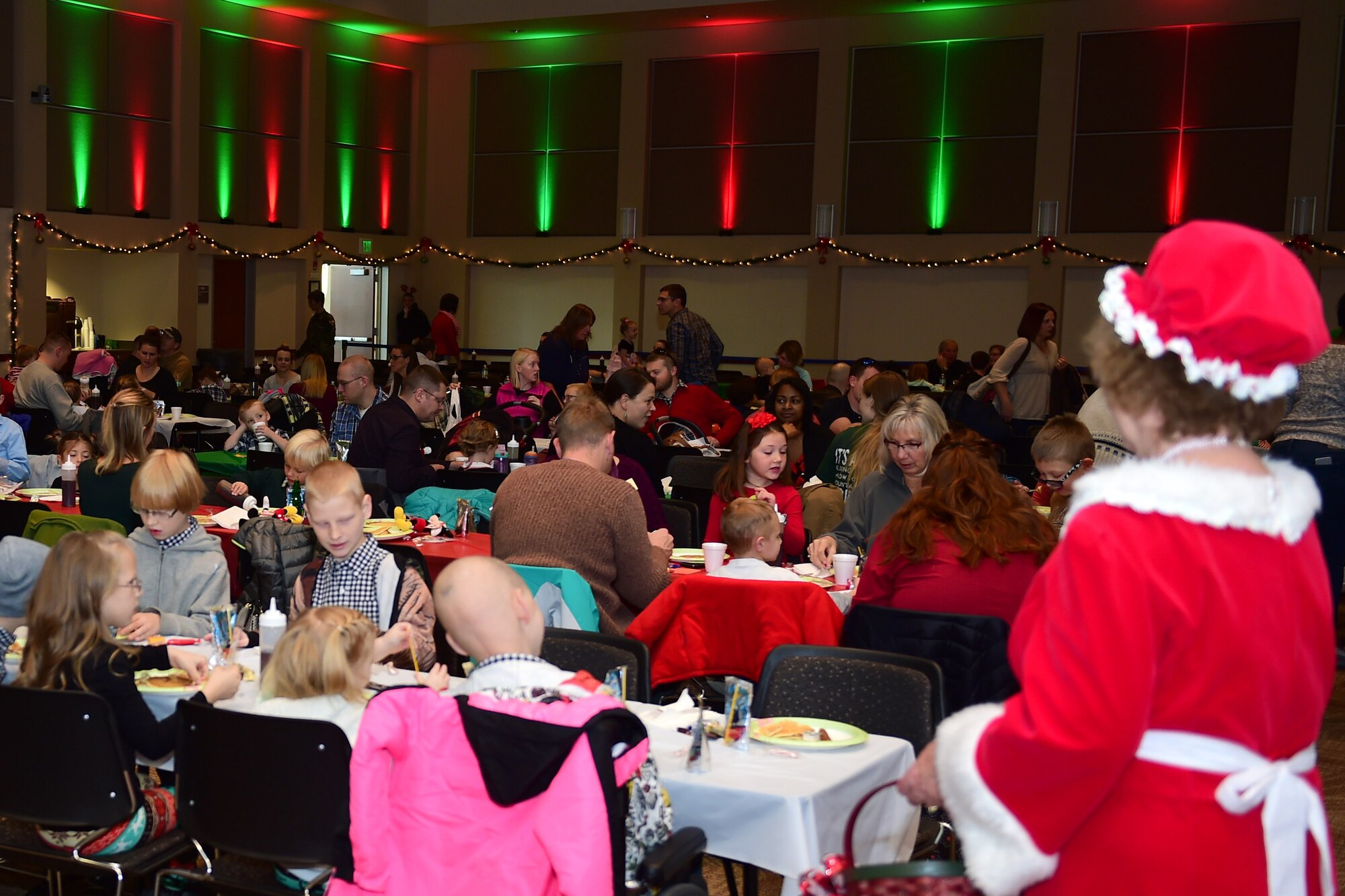 Mrs. Claus watches over the participants as they eat at a Breakfast with Santa event Dec. 3, 2016, on Buckley Air Force Base, Colo. Claus spent the morning greeting children and handing out candy canes. (U.S. Air Force photo by Airman Jacob Deatherage/Released)