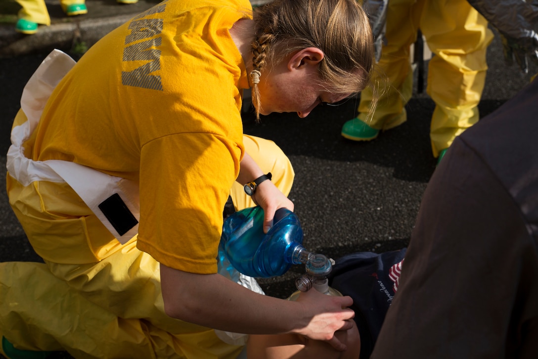 U.S. Navy Seaman Rebecca Mann, a member of the hazardous material team with the Robert M. Casey Medical and Dental Clinic, supplies air to her mock patient at Marine Corps Air Station, Japan, Dec. 1, 2016. The clinic holds decontamination training biannually to prepare the base for real-world chemical contaminations. (U.S. Marine photo by Lance Cpl. Gabriela Garcia-Herrera)