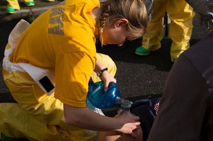 U.S. Navy Seaman Rebecca Mann, a member of the hazardous material team with the Robert M. Casey Medical and Dental Clinic, supplies air to her mock patient at Marine Corps Air Station, Japan, Dec. 1, 2016. The clinic holds decontamination training biannually to prepare the base for real-world chemical contaminations. (U.S. Marine photo by Lance Cpl. Gabriela Garcia-Herrera)