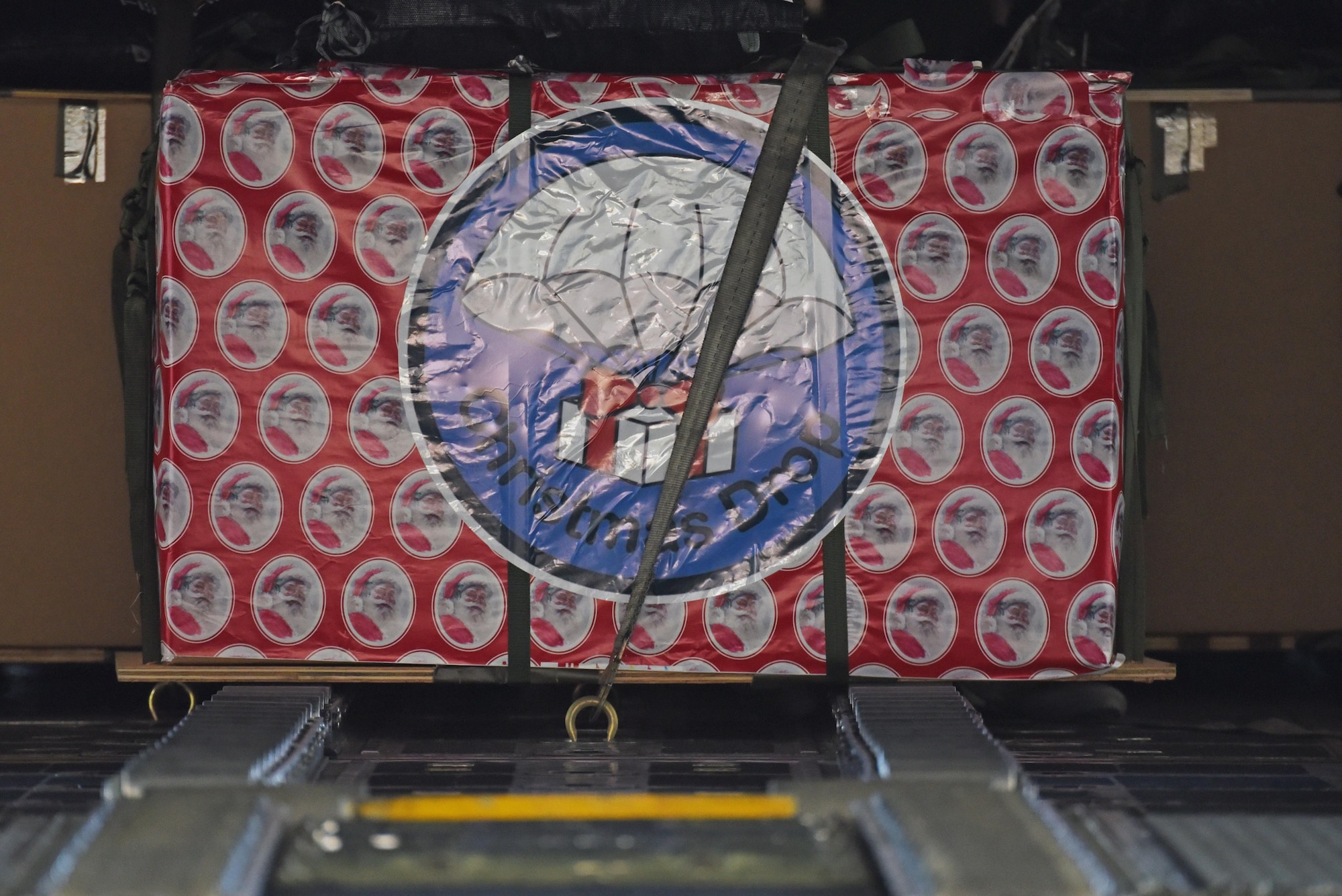 A wrapped Christmas box sits in a C-130 Hercules Dec. 6, 2016, at Andersen Air Force Base, Guam. This year marks 65 years of Operation Christmas Drop which provides joint airlift training opportunities for both peace and wartime efforts.(U.S. Air Force Photo by Airman 1st Class Jacob Skovo)