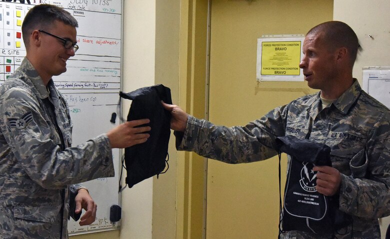 Master Sgt. Michael Bergquist, a chaplain assistant with the 379th Air Expeditionary Wing, right, gives Senior Airman Jeremy Whitfield, a ground radar technician with the 727th Expeditionary Air Control Squadron, Detachment 3, during the monthly “blitz,” at Al Udeid Air Base, Qatar, Nov. 30, 2016. The blitz is organized to reach out to Airmen that work the night shift because they don’t usually have the same opportunity to interact with helping agency team members that day shift Airmen do. (U.S. Air Force photo by Senior Airman Cynthia A. Innocenti)