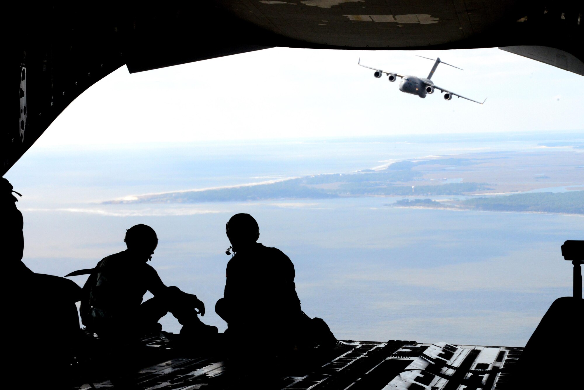 Staff Sgt. Jeffrey Michal, left, and Master Sgt. Gregory Long, right, 14th Airlift Squadron loadmasters, enjoy the view during a Key Spouse orientation flight heading to Northfield Auxiliary Airfield, S.C., Mar. 5, 2016. The C-17 Globemaster III has been stationed at Joint Base Charleston since 1993.