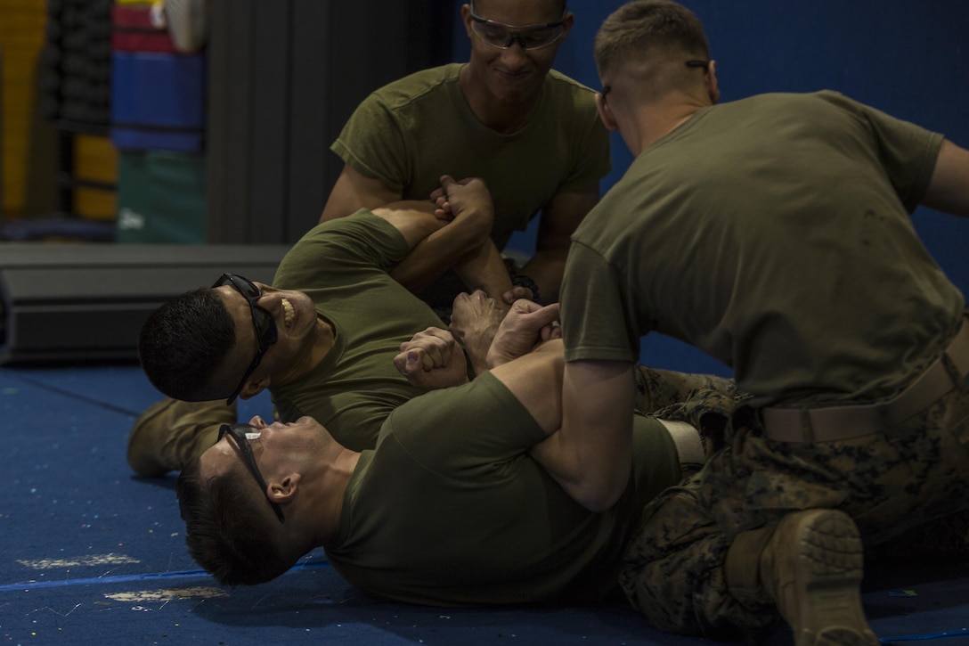 U.S. Marines with the Provost Marshal’s Office are tased to demonstrate a daisy-chain take down during Taser Certification Training at Marine Corps Air Station Iwakuni, Japan, Nov. 31, 2016. Individual prongs from the X26 Taser were fired at the two Marines before simulating a fight where touching each other completed the electrical circuit causing neuromuscular incapacitation. Neuromuscular incapacitation causes the subject’s muscles contract and lock up, making the individual unable to move. (U.S. Marine Corps photo by Cpl. Aaron Henson)