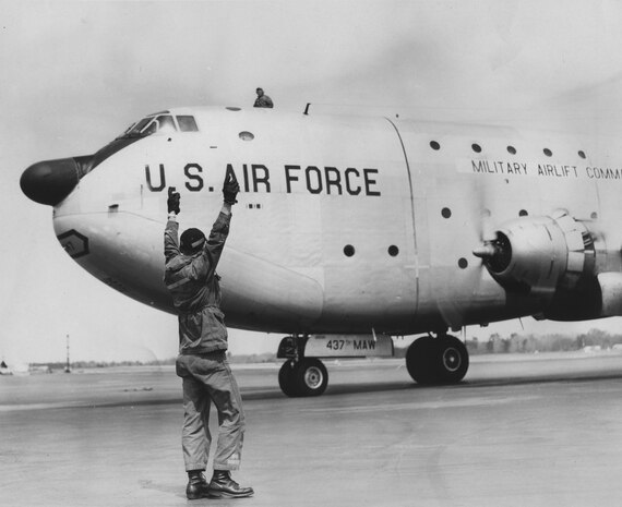 An Airman marshalls a C-124 Globemaster II on Charleston Air Force Base, South Carolina in the 1960s. The C-124 was based here from 1958 until 1969. A static display of the C-124 Globemaster II stands at the Air Park here.