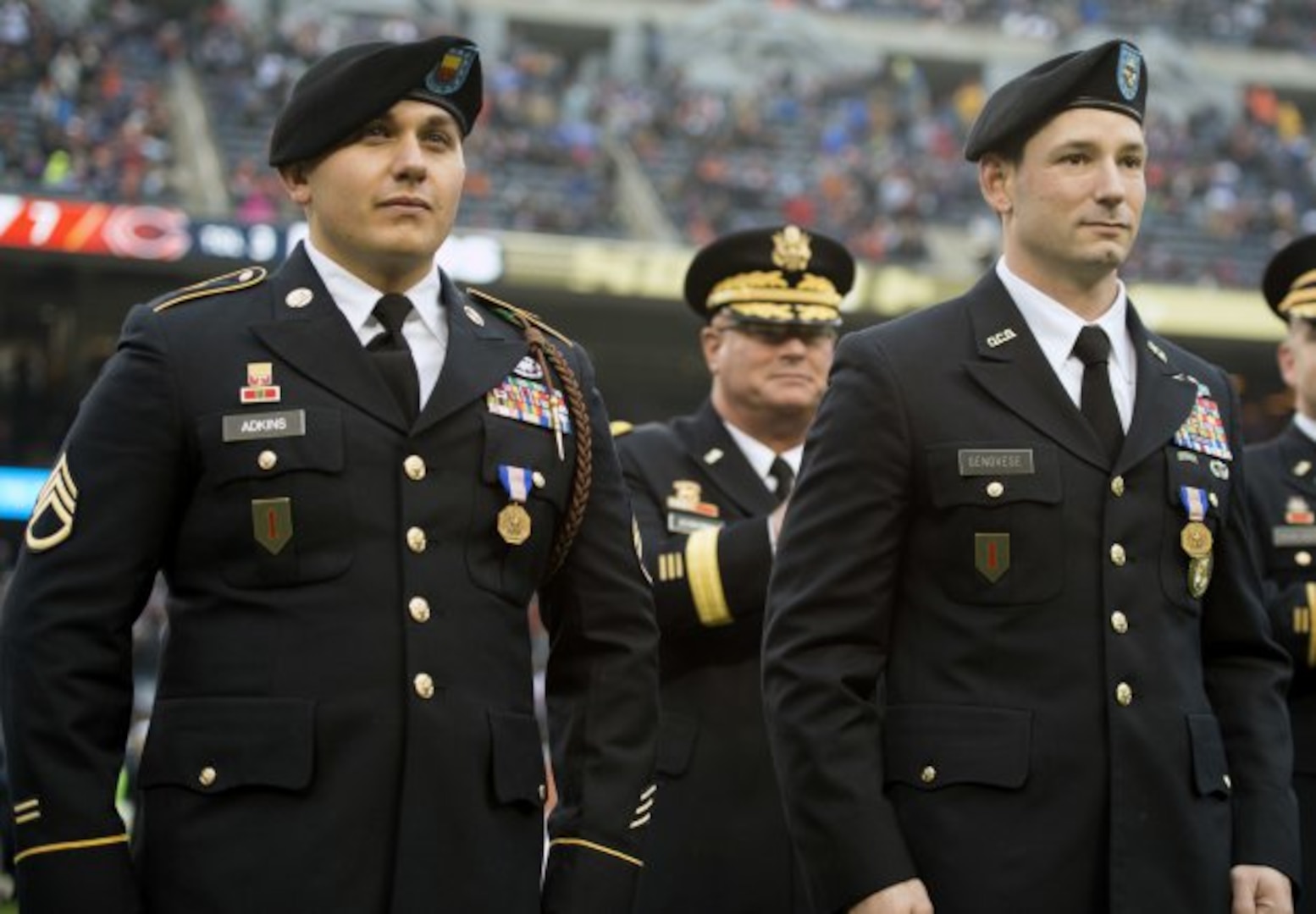 Illinois Army National Guard Staff Sgt. Jeremy Adkins, left, and Officer Candidate Tony Genovese, both of Chicago, stand at attention in the center of Soldiers Field to be recognized by the crowd prior to them being awarded the Soldiers Medal during the Chicago Bears "Salute to Service" game Nov. 27, 2016. Assistant Adjutant General Brig. Gen. Michael Zerbonia is in background. The Soldiers were recognized for their bravery in pulling a driver from a burning vehicle following an accident on May 11, 2016. 