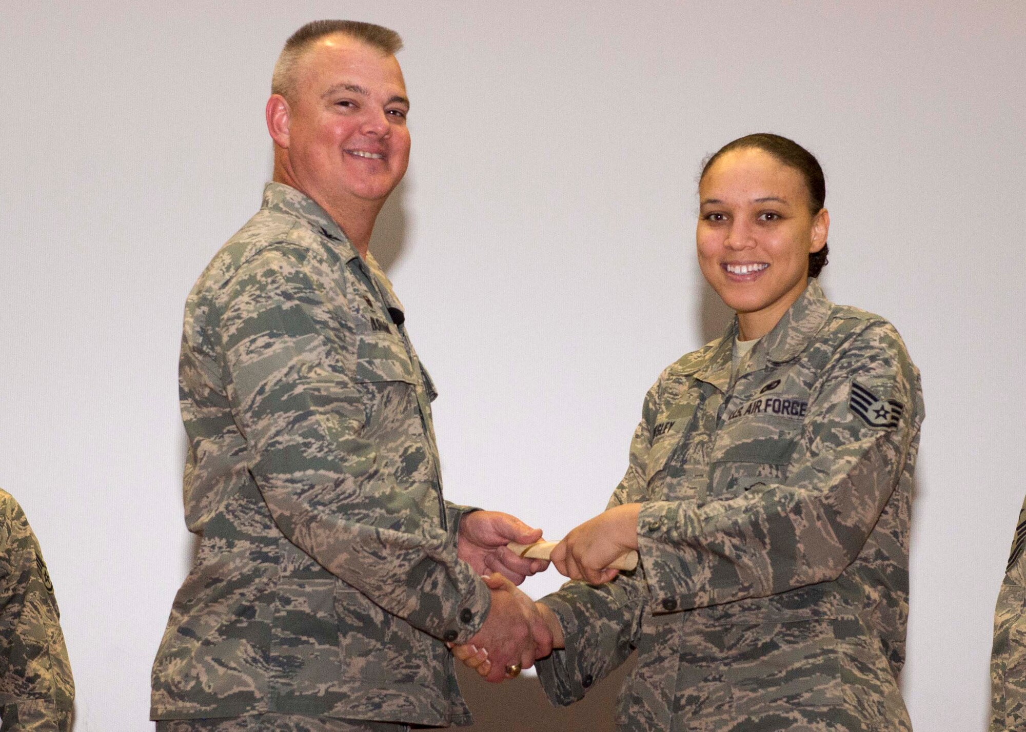Staff Sgt. Savanna Wesley, 512th Security Forces Squadron, shakes hands with Col. Scott D. Durham, 512th AW commander, during the wing's Community College of the Air Force graduation ceremony, Dec. 3, 2016, Dover Air Force Base, Del. The wing surpassed their goal of awarding 100 CCAF degrees during 2016 and awarded 109 degrees. (U.S. Air Force Photo/Staff Sgt. Renee Jackson)