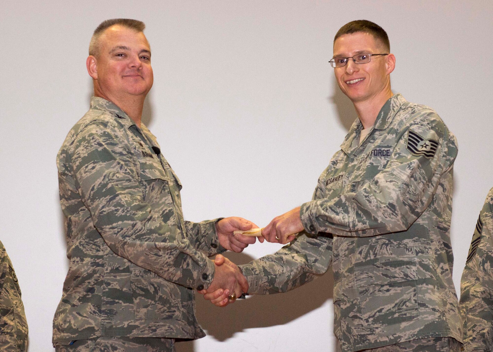 Tech. Sgt. Sean McGahuey, 512th Force Support Squadron, shakes hands with Col. Scott D. Durham, 512th AW commander, during the wing's Community College of the Air Force graduation ceremony, Dec. 3, 2016, Dover Air Force Base, Del. The wing surpassed their goal of awarding 100 CCAF degrees during the year and awarded 109 degrees. (U.S. Air Force Photo/Staff Sgt. Renee Jackson)