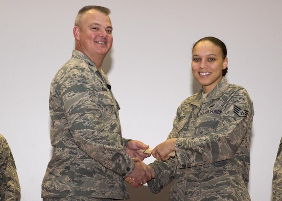Staff Sgt. Savanna Wesley, 512th Security Forces Squadron, shakes hands with Col. Scott D. Durham, 512th AW commander, during the wing's Community College of the Air Force graduation ceremony, Dec. 3, 2016, Dover Air Force Base, Del. The wing surpassed their goal of awarding 100 CCAF degrees during 2016 and awarded 109 degrees. (U.S. Air Force Photo/Staff Sgt. Renee Jackson)
