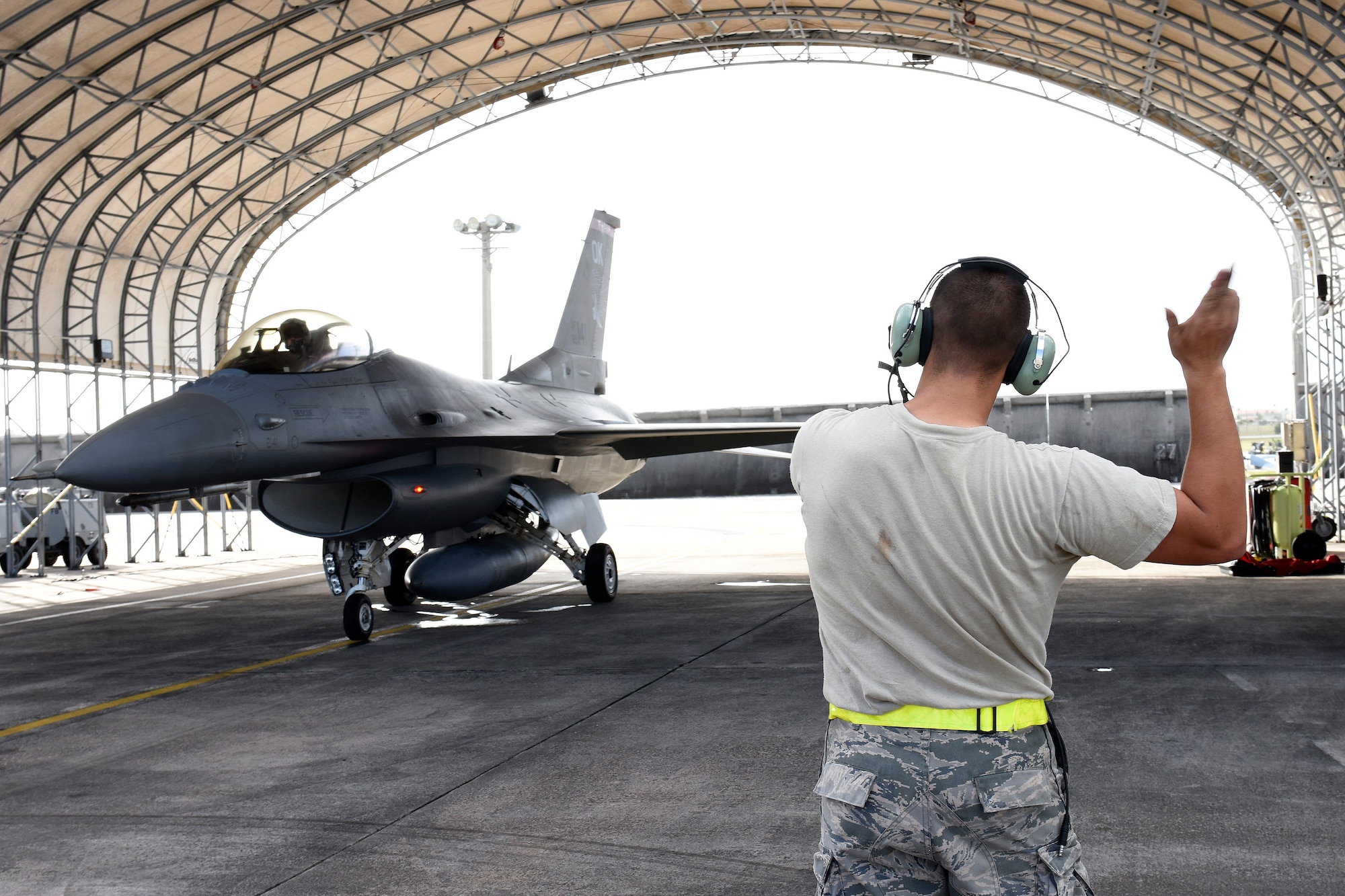 U.S. Air Force Senior Airman Joshua Utter, a crew chief assigned to the 112th Expeditionary Fighter Squadron, marshals an F-16 Fighting Falcon piloted by Capt. Roy “Grease” Poor during exercise Cope North 2016 on Feb. 15, 2016 at Andersen Air Force Base, Guam. CN16 includes 22 total flying units and nearly 3,000 personnel from six countries and continues the growth of strong, interoperable and beneficial relationships within the Indo-Asia-Pacific region through integration of airborne and land-based command and control assets. (U.S. Air National Guard photo by Staff Sgt. Shane Hughes/Released)