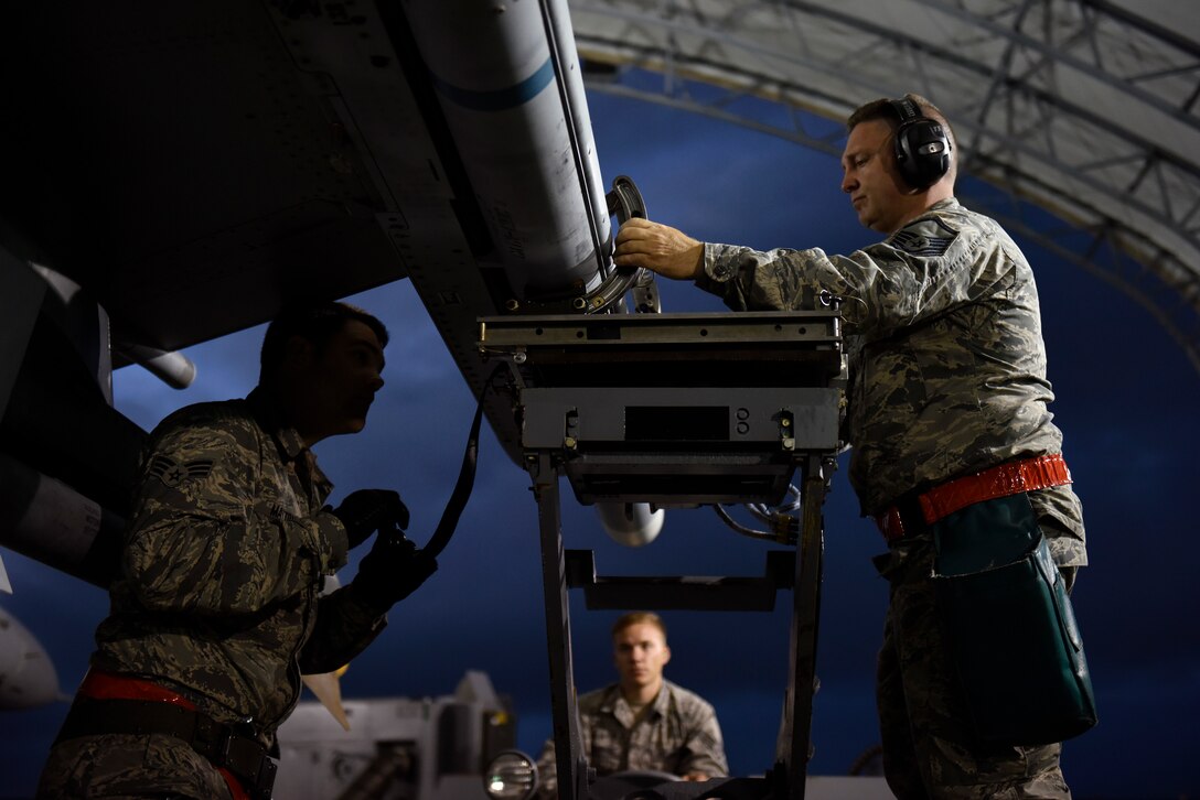 U.S. Air Force Senior Airman Justin Mattoni, Staff Sgt. Devon Childress and Master Sgt. Davis Mills, a weapons load team assigned to the 112th Expeditionary Fighter Squadron, conduct a cross-load Feb. 22, 2016, during exercise COPE NORTH 16 at Andersen Air Force Base, Guam. Training exercises such as CN16, allow the U.S., Japan and Australia air forces to develop combat capabilities, enhancing air superiority, electronic warfare, air interdiction, tactical airlift and aerial refueling. (U.S. Air National Guard photo by Staff Sgt. Shane Hughes/Released)