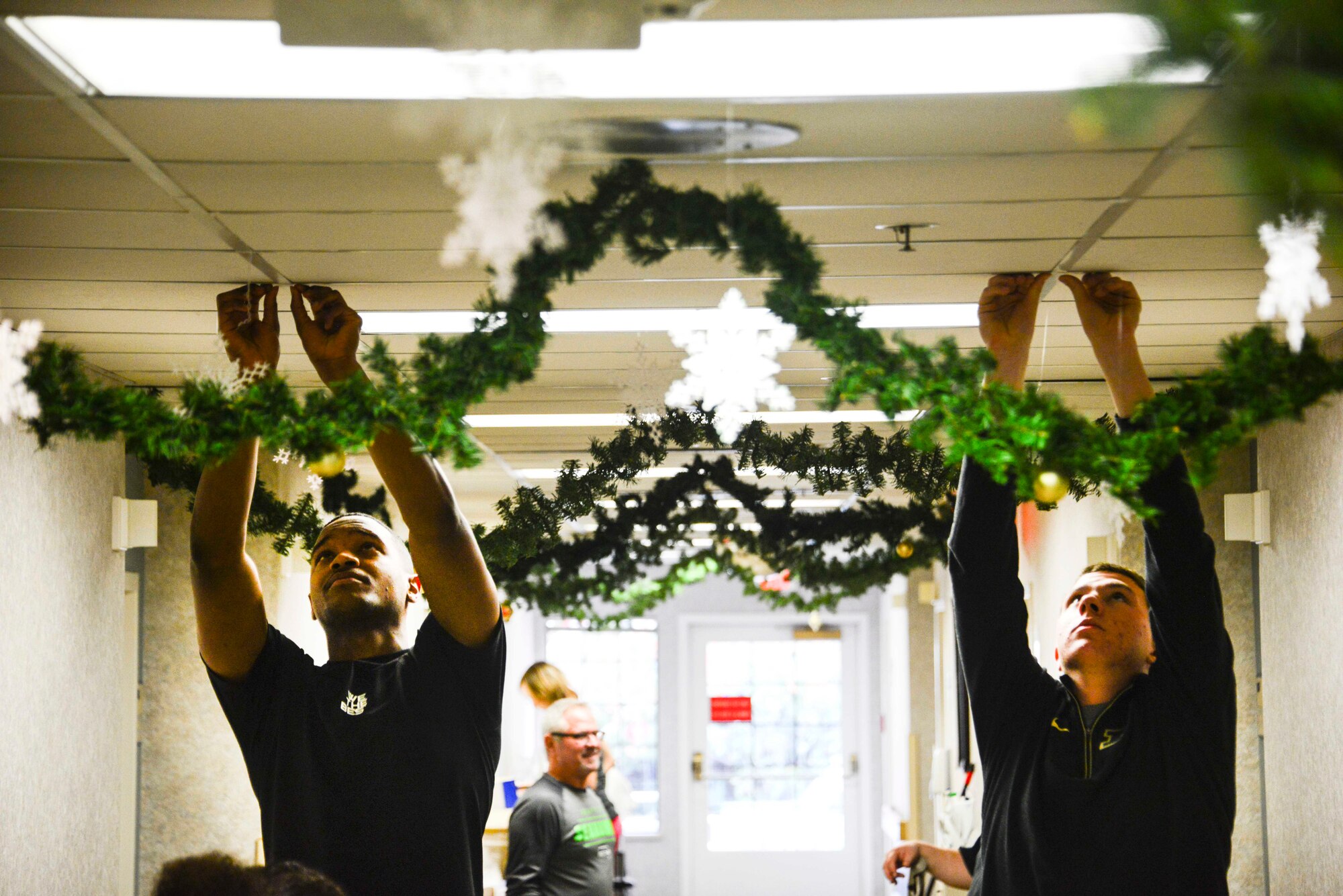 Airmen from the 92nd Logistics Readiness Squadron hang decorations for veterans during the 92nd LRS annual volunteer event Dec. 2, 2016, at the Spokane Veterans Home in Spokane. Most of the decorations were donated by either the staff members, volunteers themselves or from the families of veterans. (U.S. Air Force photo/Senior Airman Janelle Patiño)
