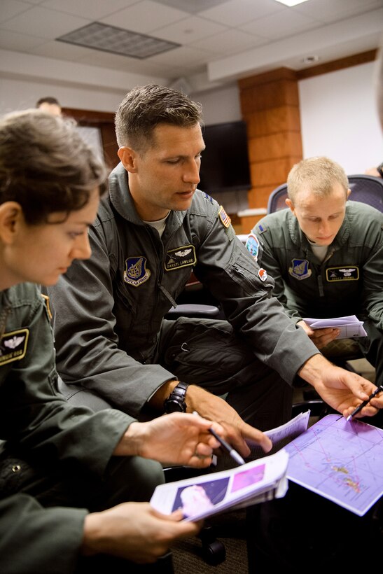 Air Force Capt. Darryl Lawlor, center, briefs his flight crew before participating in Operation Christmas Drop at Andersen Air Force Base, Guam, Dec. 5, 2016. Lawlor is a pilot assigned to the 36th Airlift Squadron. U.S., Australian and Japanese aircrews conducted the training event in which C-130 aircrews perform low-altitude airdrops while providing critical supplies to 56 islands. Air Force photo by Senior Airman Delano Scott