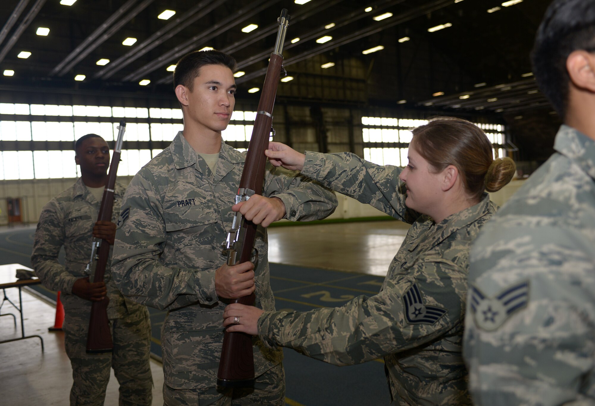 Staff Sgt. Michelle Hoyal, an honor guard flight sergeant assigned to the 28th Force Support Squadron, adjusts Senior Airman James Pratt, an equipment operator assigned to the 28th Civil Engineer Squadron, during rifle drill at Ellsworth Air Force Base, S.D., Dec. 2, 2016. The mission the Ellsworth Honor Guard is to act as representatives for Airmen to both the American public and the world (U.S. Air Force photo by Airman 1st Class Donald C. Knechtel)