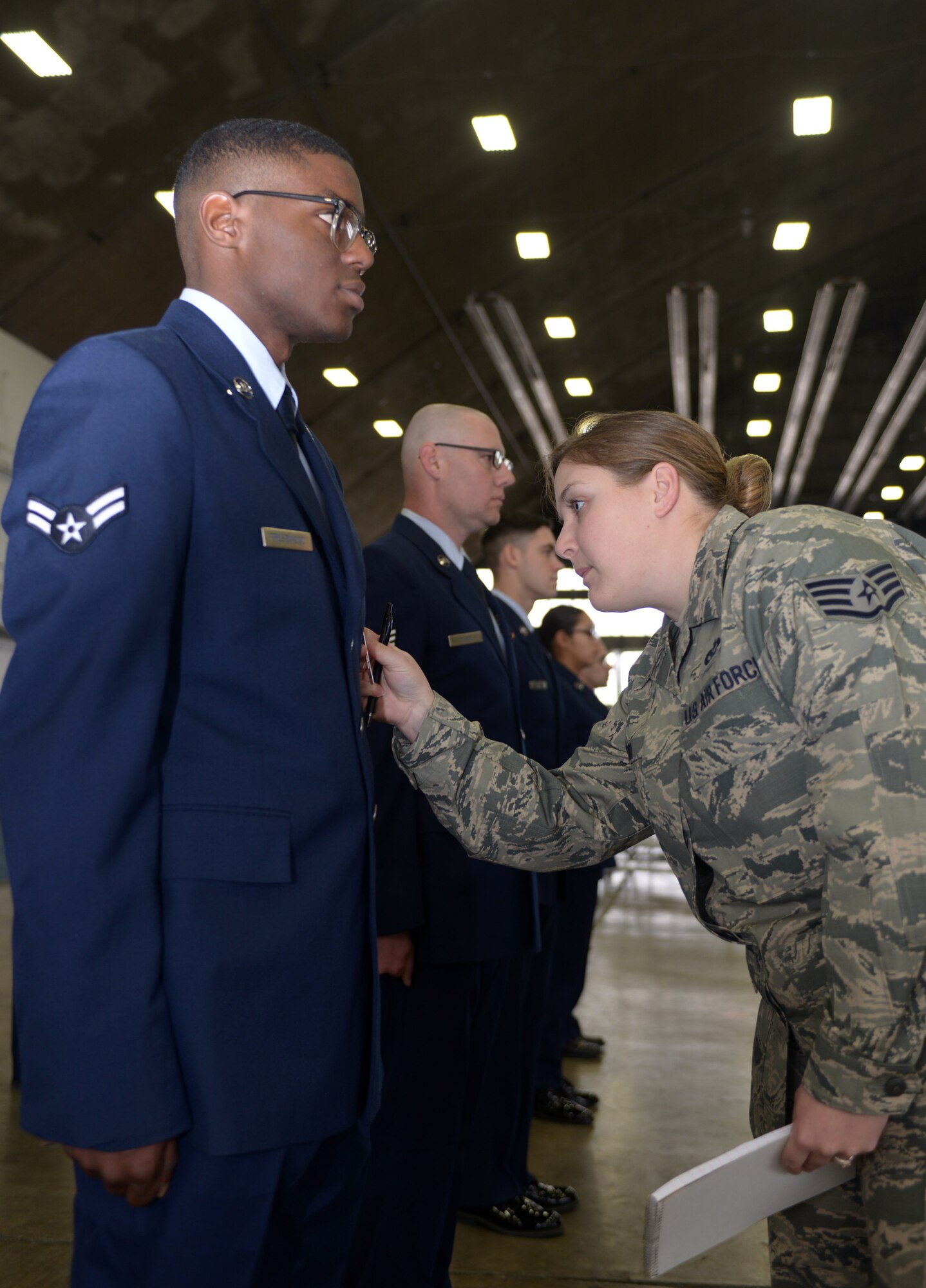 Staff Sgt. Michelle Hoyal, an honor guard flight sergeant assigned to the 28th Force Support Squadron, inspects Airman 1st Class Roger Presswoods’ uniform during open ranks in the Pride hangar at Ellsworth Air Force Base, S.D., Dec. 2, 2016. The Ellsworth Honor Guard is responsible for providing military honors throughout a 114,636 square-mile area including South Dakota, western Nebraska and northern Wyoming. (U.S. Air Force photo by Airman 1st Class Donald C. Knechtel)