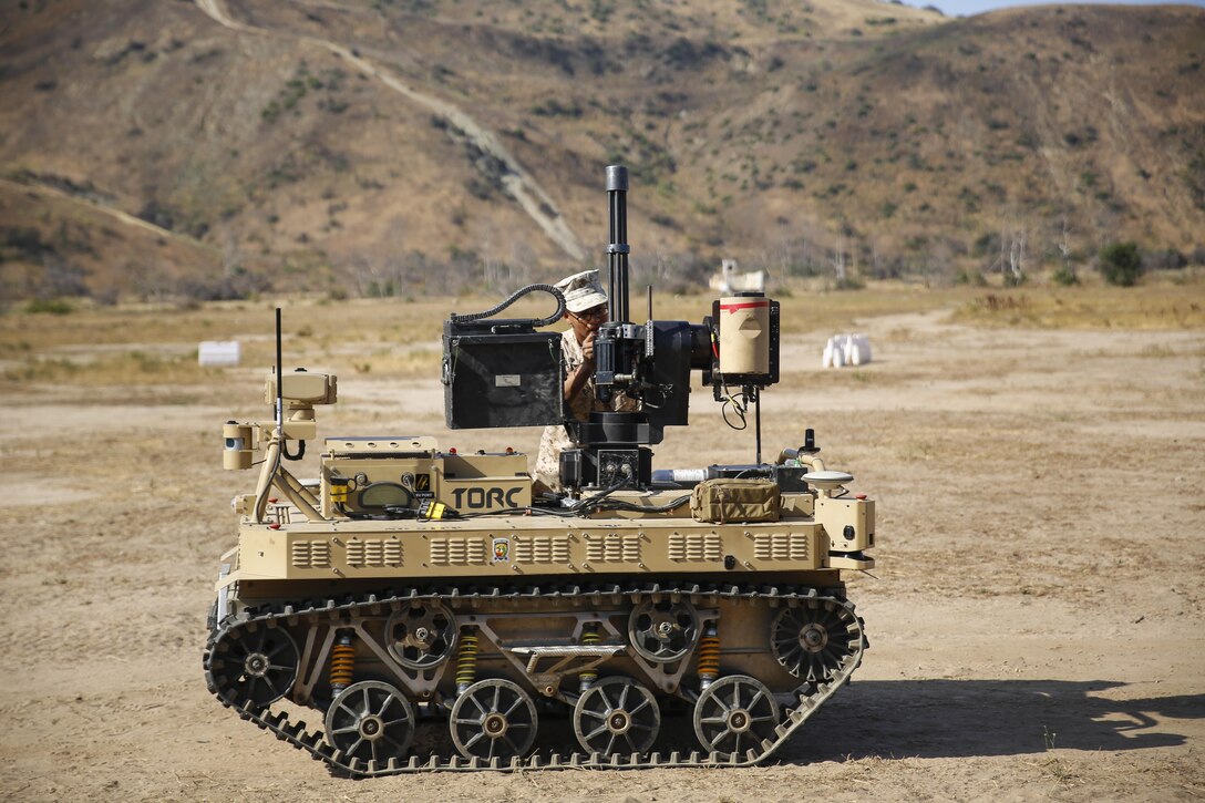 Marine Corps Lance Cpl. Jorge Sainz attaches the M134 Minigun to a robotic vehicle modular system at Camp Pendleton, Calif., June 23, 2016. The Marine Corps Warfighting Laboratory conducted an air-ground integrated experiment to explore new gear for potential use. Sainz is a rifleman assigned to Kilo Company, 3rd Battalion, 5th Marine Regiment. Marine Corps photo by Lance Cpl. Frank Cordoba