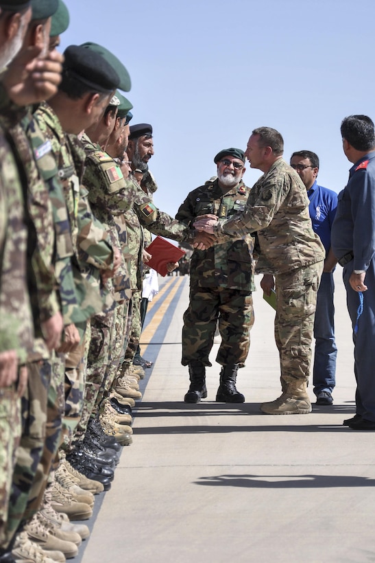 U.S. Air Force Brig. Gen. David Hicks walks with Afghan Air Force Brig. Gen. Sayed Assadulah, commander of the Shindand Wing, to meet Sindand airmen in Shindand, Afghanistan, July 17, 2016. Hicks is the commander of the 438th Air Expeditionary Wing and Train, Advise, Assist Command Air. U.S. airmen assigned to the command traveled from Kabul, Afghanistan, to the Shindand Air Wing for a visit. Air Force photo by Capt. Jason Smith