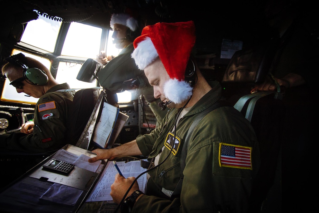 Air Force Senior Master Sgt. Ed Sponenburg, foreground, annotates flight information during Operation Christmas Drop over the Micronesian islands, Dec. 5, 2016. Sponenburg is a flight engineer assigned to the 36th Airlift Squadron. Air Force photo by Senior Airman Delano Scott